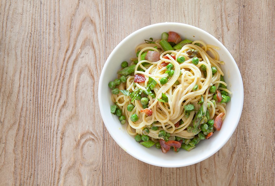 En tallerken med pasta carbonara med rter.