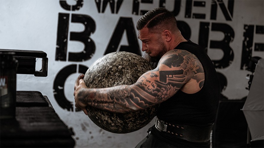 En mand b�rer en atlas-sten.