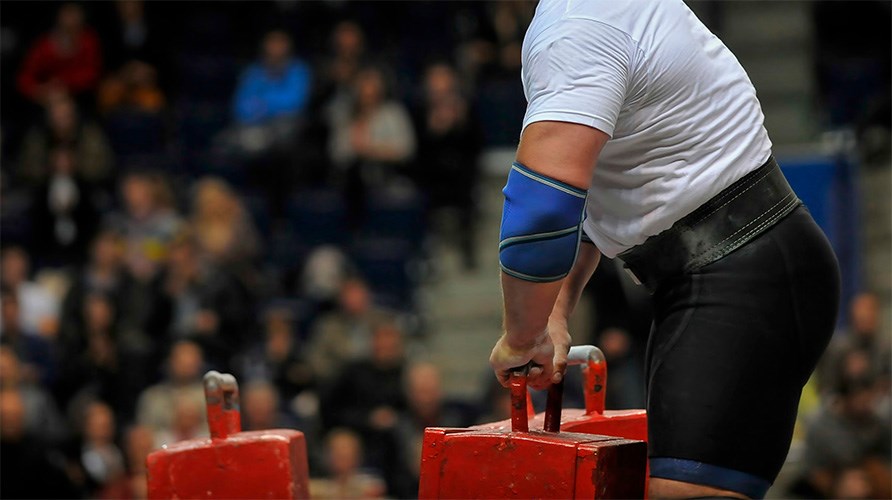 Mand der konkurrerer i strongman og holder en tung vgt i sine hnder.