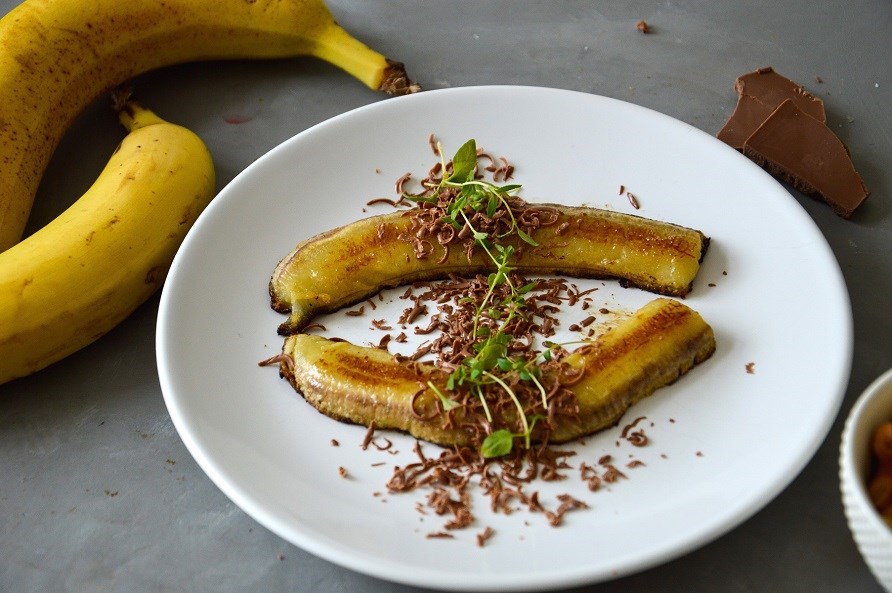 Billede af grillede bananer med chokolade serveret p et hvidt fad.