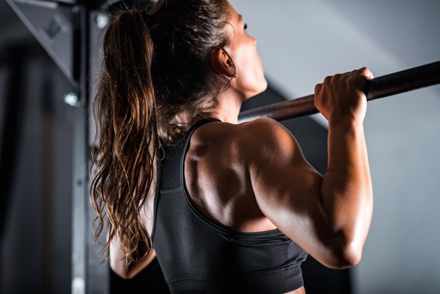 Kvinde der laver chin-ups i fitnesscenter