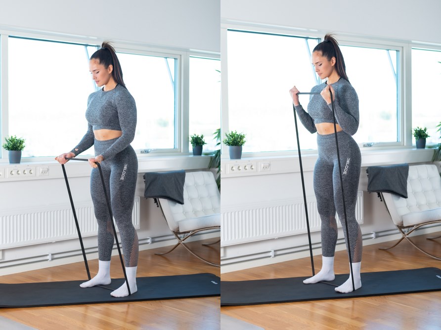 En kvinde er ved at udføre biceps curls med en elastik.