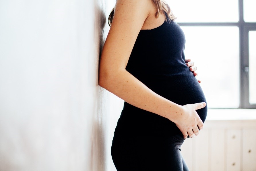 En gravid kvinde holder om hendes mave.