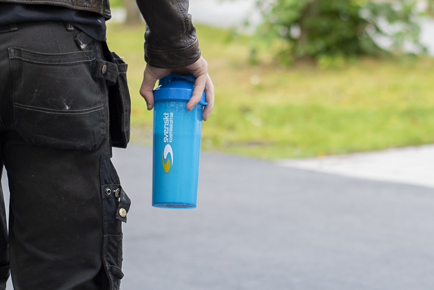 En mand holder en bl shaker i hnden.
